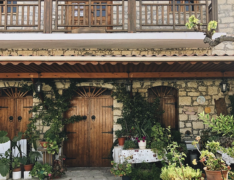 fachada de finca rústica con madera, piedra y plantas